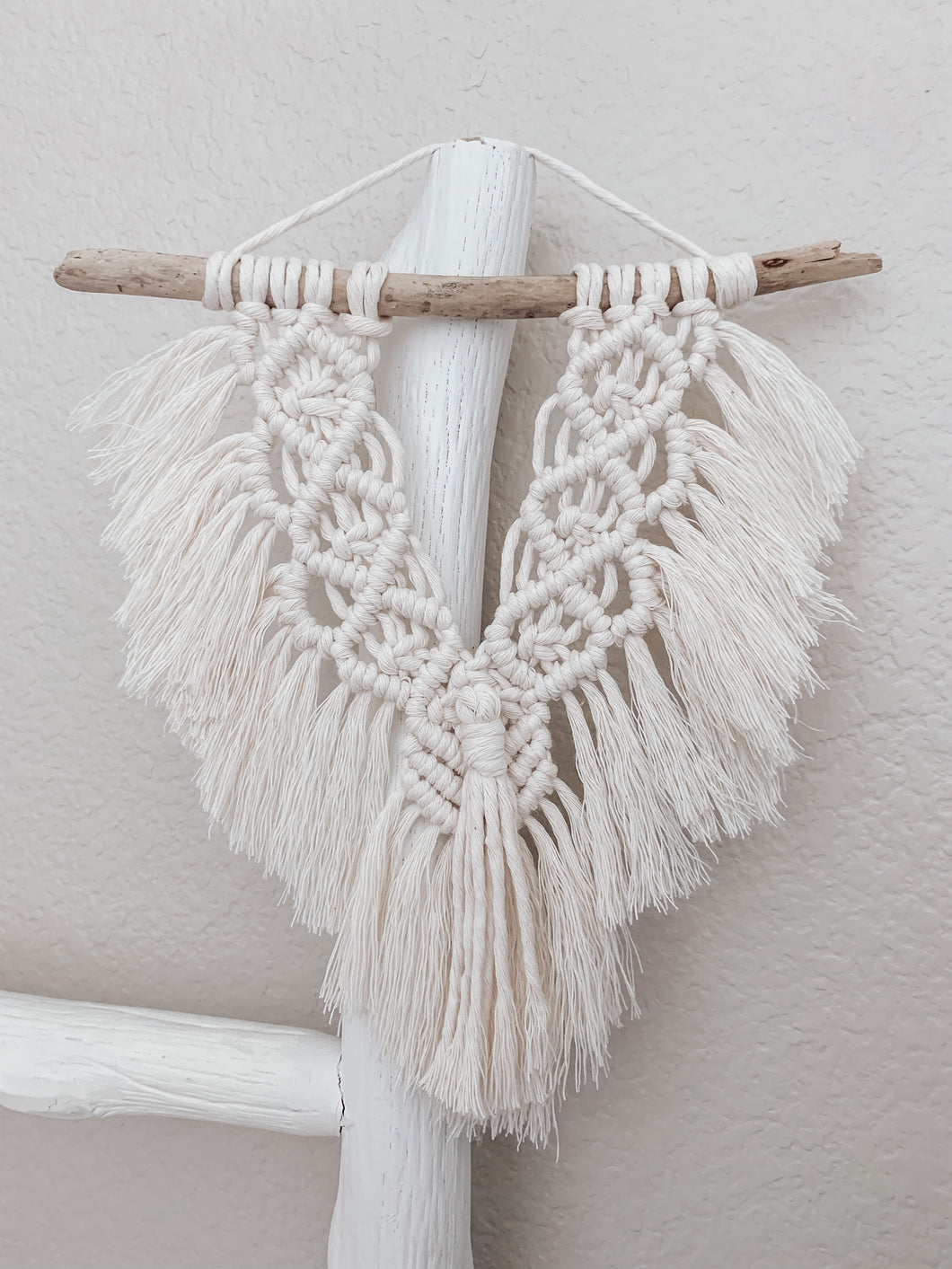 White mini fringe wall hanging made up of cotton cord hand knotted on driftwood