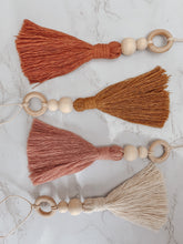 Load image into Gallery viewer, Four hanging tassel charms with wooden beading detail shown in white, blush, terra cotta, and mustard colors 

