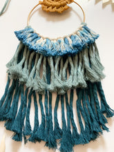 Load image into Gallery viewer, A macrame wall hanging with mustard colored cotton cord to reflect a sunset and a mix of blue toned cotton cord fringe hand tied to a golden hoop 
