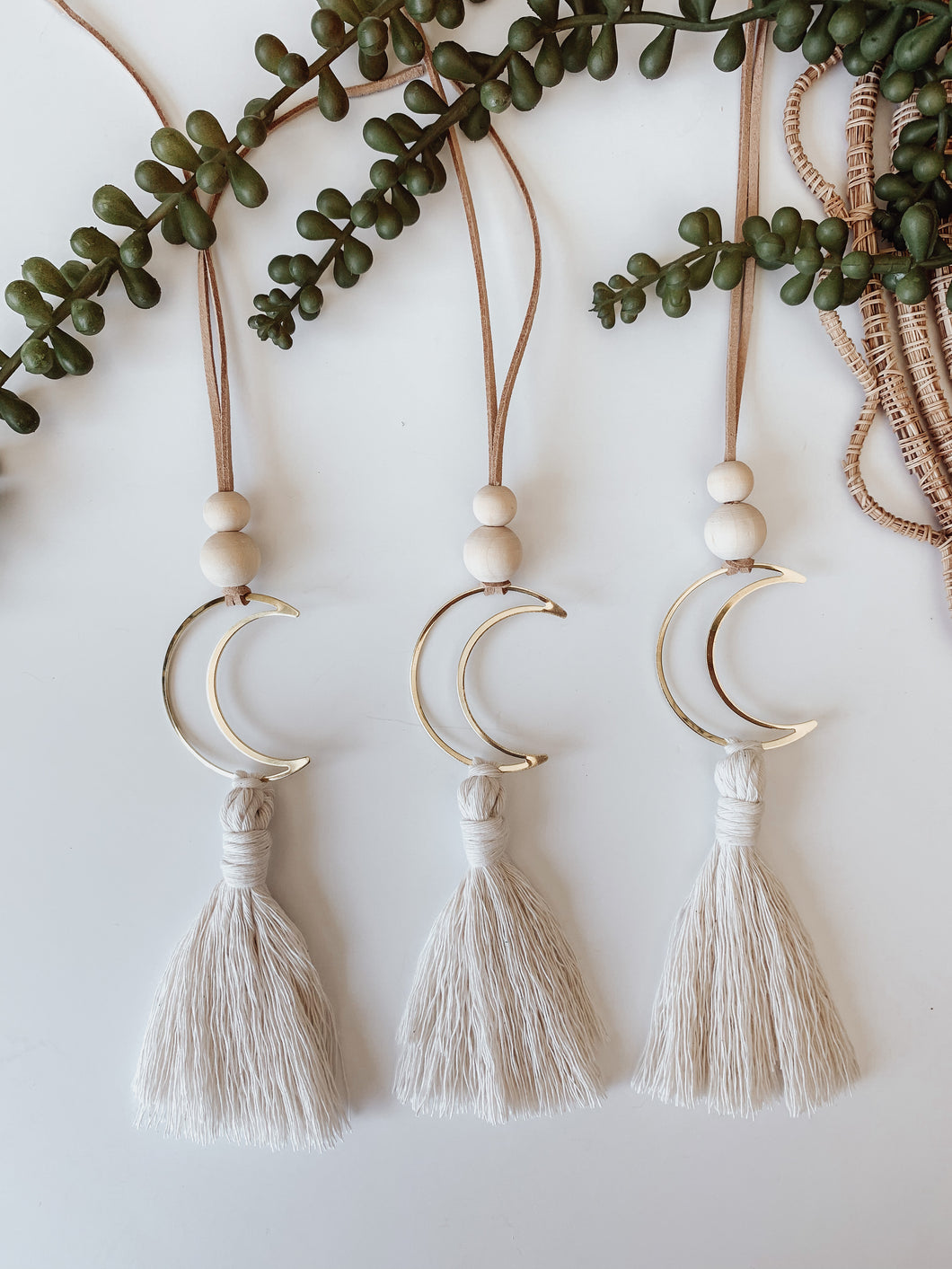 Three gold crescent moon charms with cotton tassels 