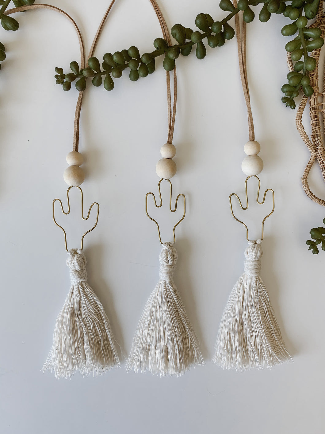 Set of three brass cactus charms with white cotton tassel 