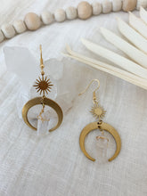 Load image into Gallery viewer, A pair of drop earrings with raw brass crescent and clear quartz charm
