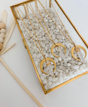 Load image into Gallery viewer, Three gold plated chain necklaces with gold plated crescent and clear quartz charms seen in a jewelry box 

