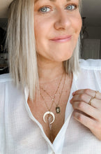 Load image into Gallery viewer, A model showing off a gold plated chain necklace with gold plated crescent and clear quartz charm 
