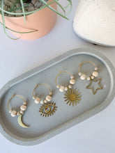 Load image into Gallery viewer, Set of four boho style wine charms made of brass charms and wooden beads seen on a tray
