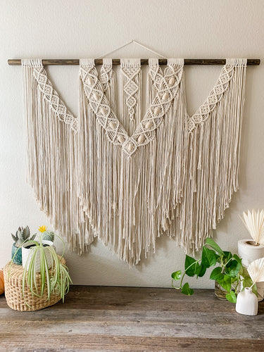 A large macrame beaded wall hanging
