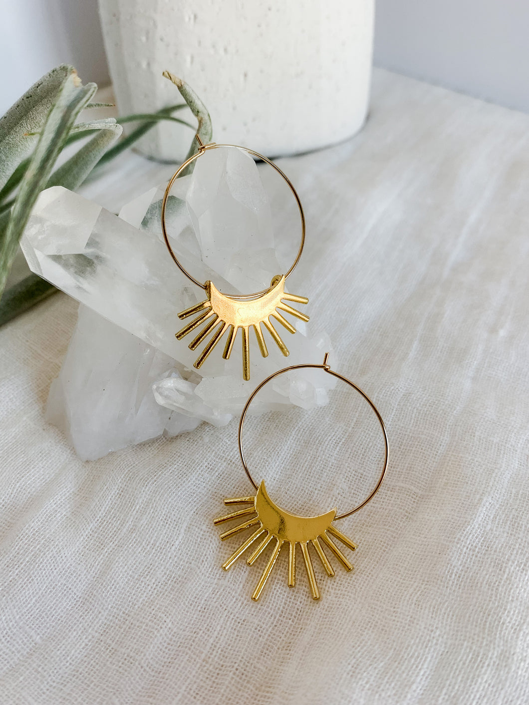 A pair of gold plated 30mm hoop earrings with a rising moon charm 
