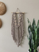 Load image into Gallery viewer, A macrame wall hanging made up of cotton cord hand knotted on local driftwood and accessorized with wood beads 
